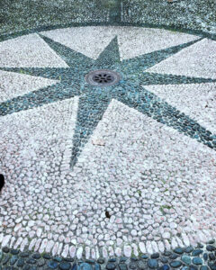 Rosa dei Venti realizzata a mosaico sul pavimento del cortile interno di Palazzo Tornielli